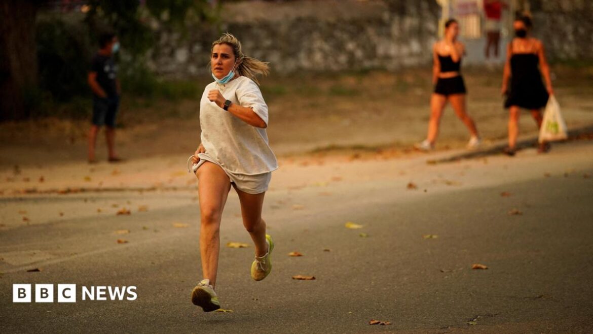 A person runs as the fire spreads in the mountains of Navaluenga, Avila, Spain