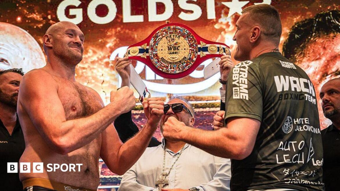 Tyson Fury and Mariusz Wach hold up their hands and face each other