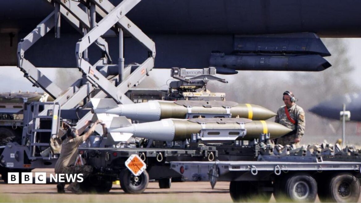 A member of the US military watches on as weapons are loaded onto an American aircraft at RAF Fairford