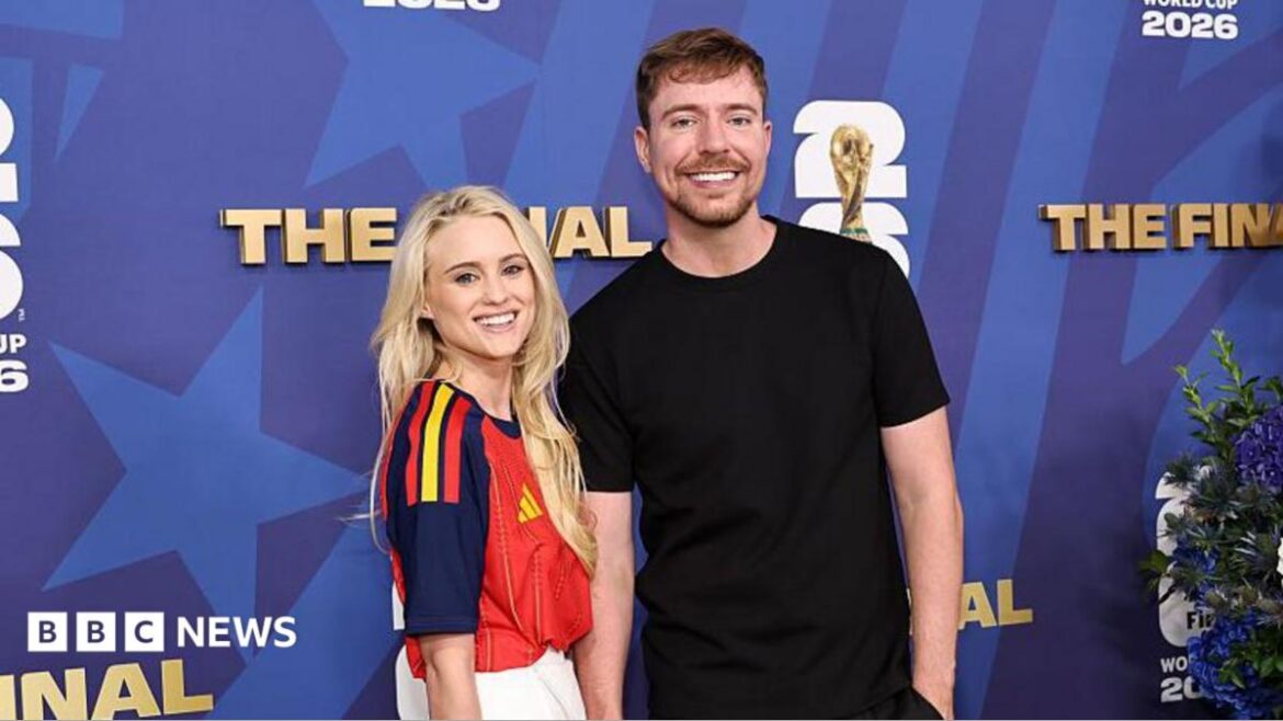 Mr Beast on the right is wearing a plain black t-shirt and black trousers. Thea Booysen is wearing a red, navy blue and