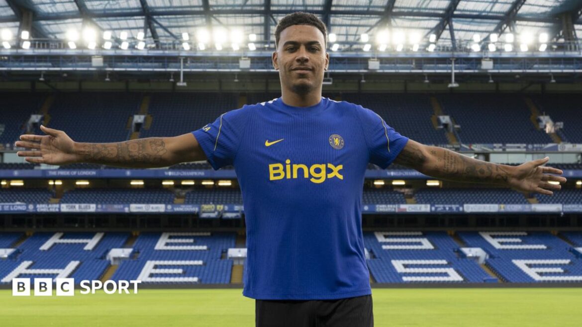 Morgan Rogers stands with his arms outstretched after joining Chelsea