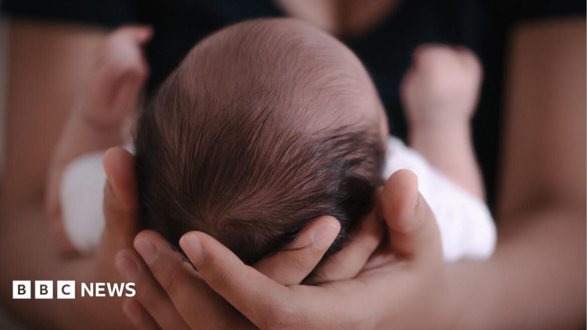 Baby cradled in arms of mother