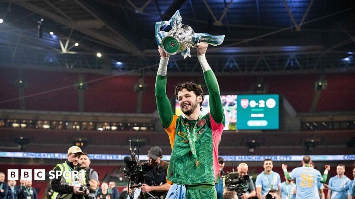 James Trafford celebrates with a trophy in his hands