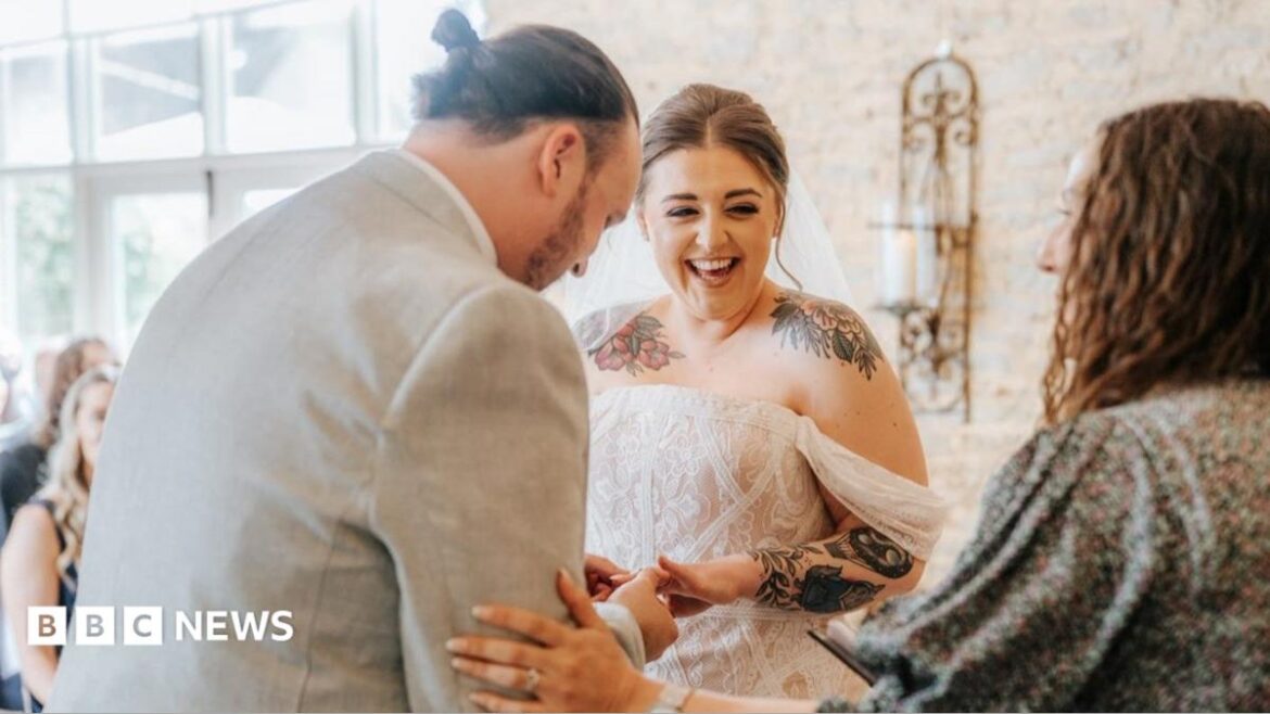 A bride looks at a celebrant and laughs and she and the groom exchange vows