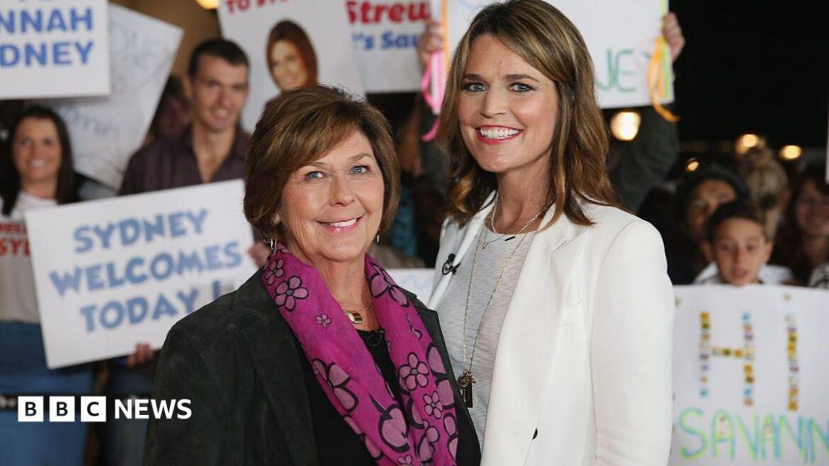 Savannah, all in white, and Nancy Guthrie in a black suit jacket and pink patterned scarf, smile as they stand shoulder to