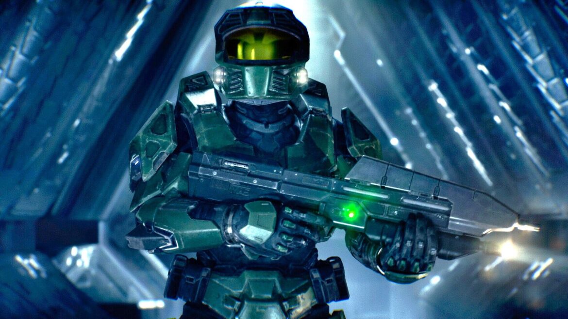 Master Chief wearing green tactical armor and a gold visor, holding a futuristic assault rifle inside a glowing blue
