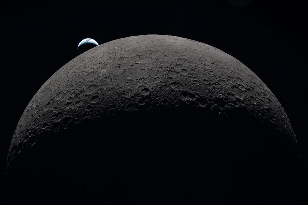The cratered Moon filling the frame with a small crescent Earth setting beyond its horizon
