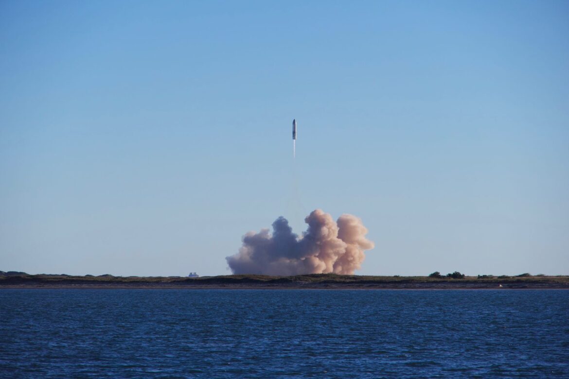A Starship prototype rising above its launch plume across the water near South Padre Island