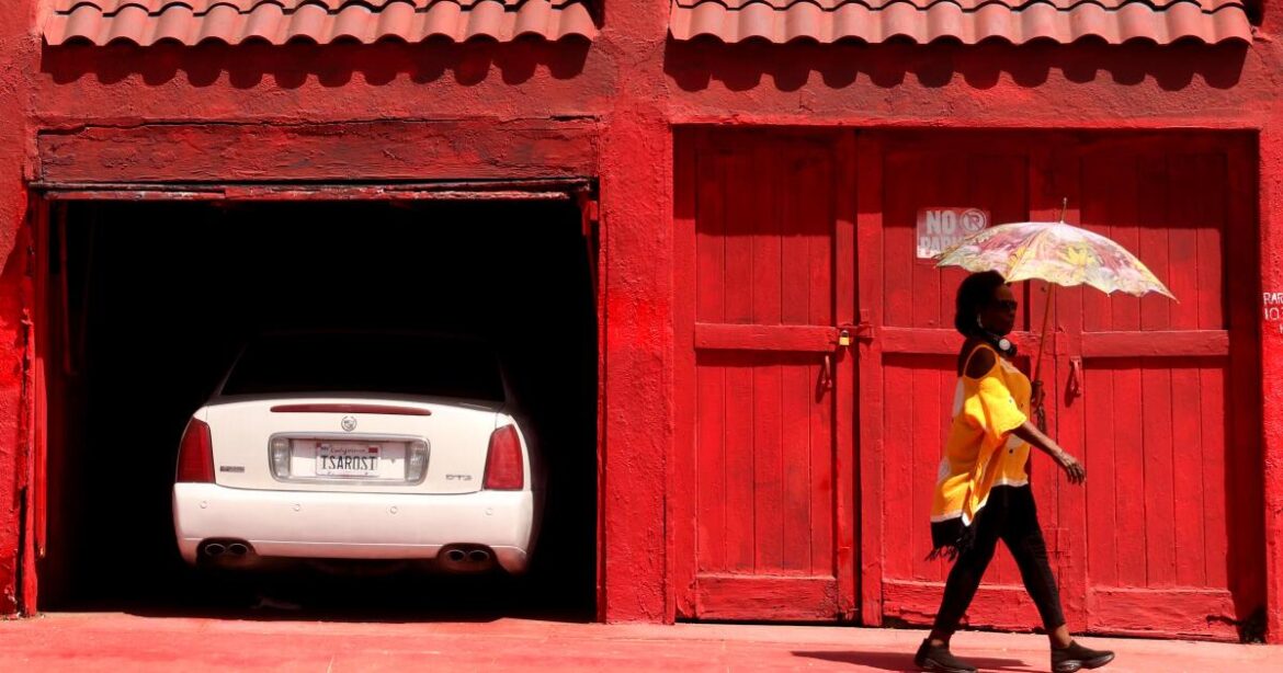 LOS ANGELES, CA - JULY 11, 2026 - - RED HOT - - Diana Jackson, 78, of Silver Lake, walks by a carport and sidewalk painted
