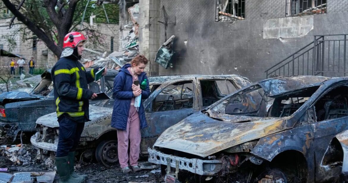 An owner looks at her damaged car following a Russia missile attack in Kyiv, Ukraine, Sunday, July 19, 2026. (AP Photo/Efrem