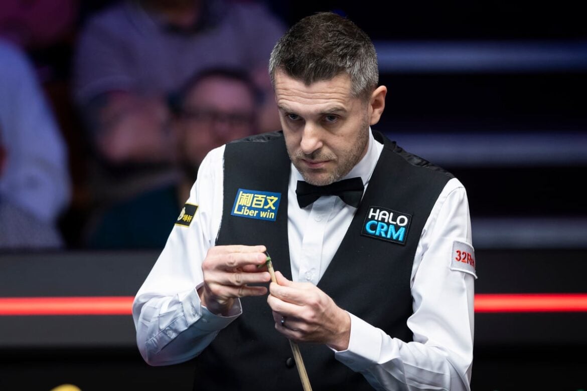 Mark Selby looks on as he chalks his cue