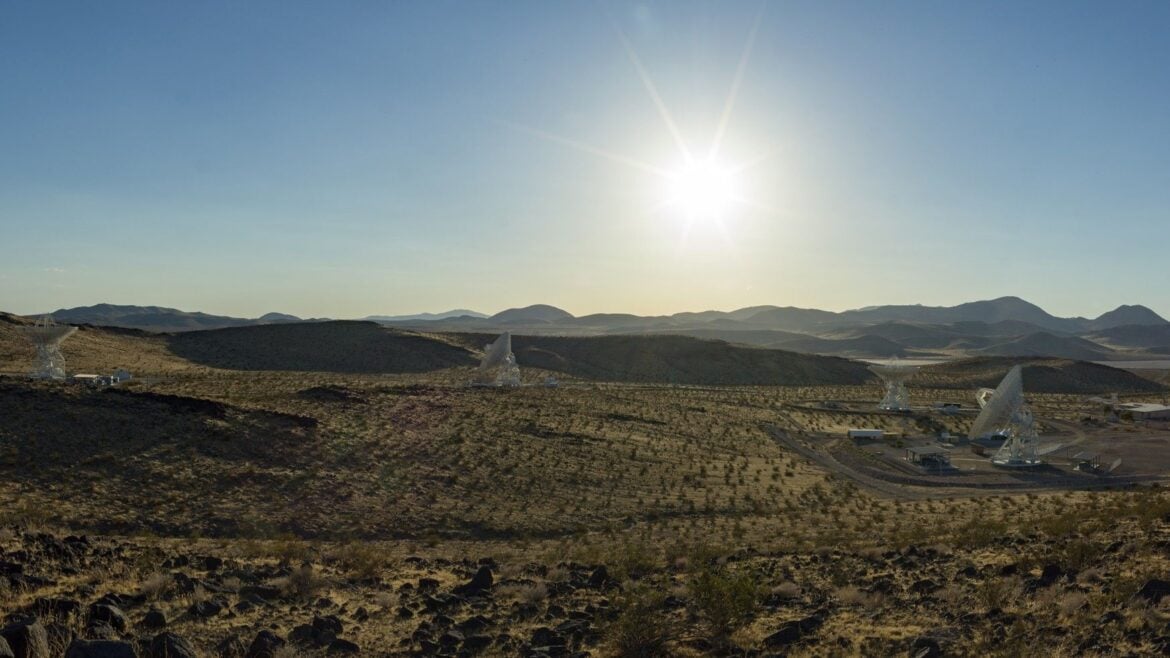 several antennas sit under a blue sky and blazing sun