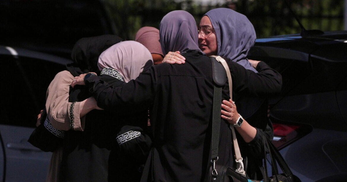 People embrace outside of the Islamic Center of San Diego, the day after a shooting, Tuesday, May 19, 2026, in San Diego