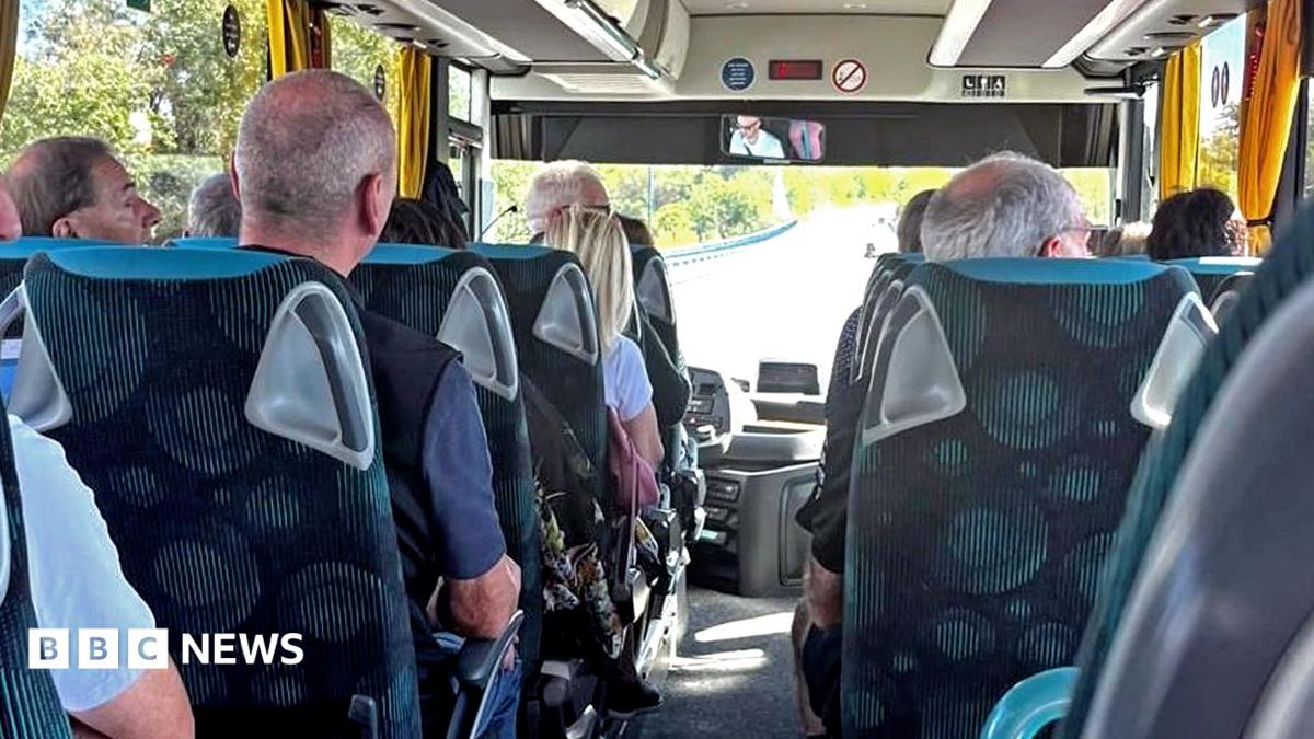 A photo showing the inside of a coach, and the backs of passengers' heads as they sit in their seats. Some are looking out