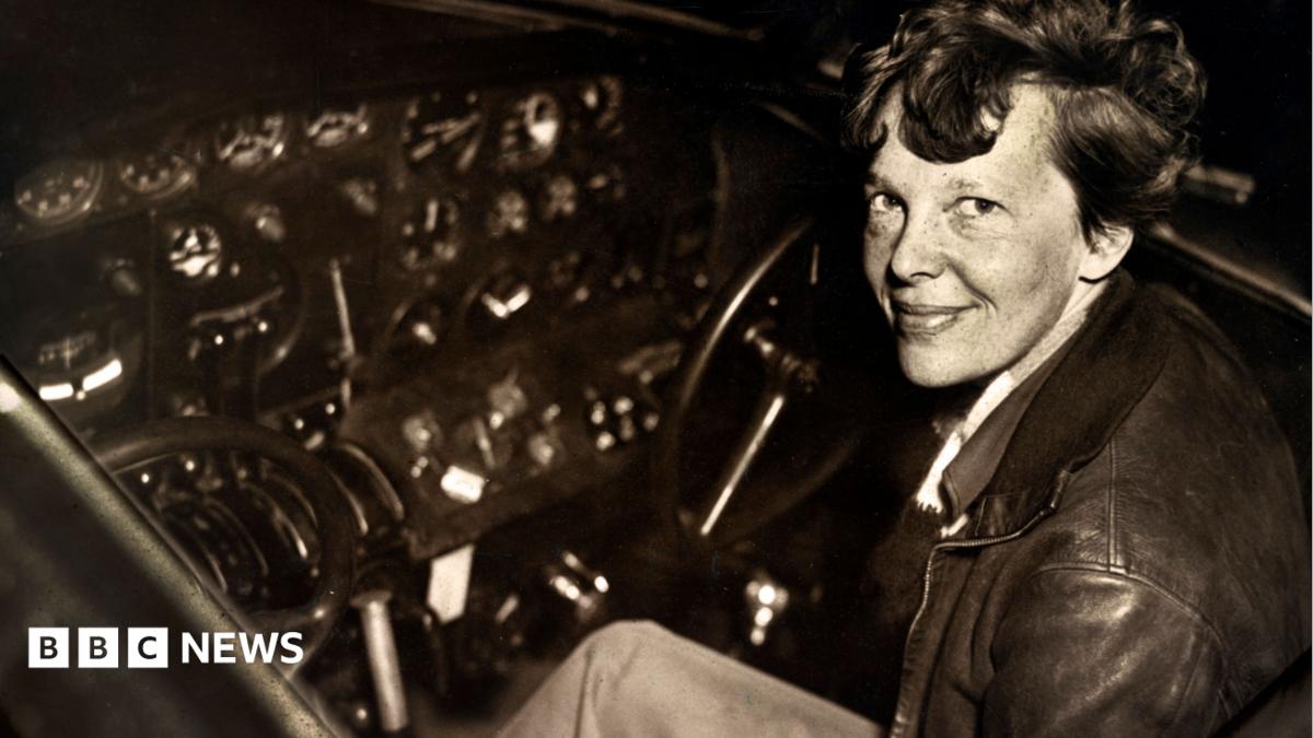 Amelia Earhart sitting in the cockpit of an Electra airplane