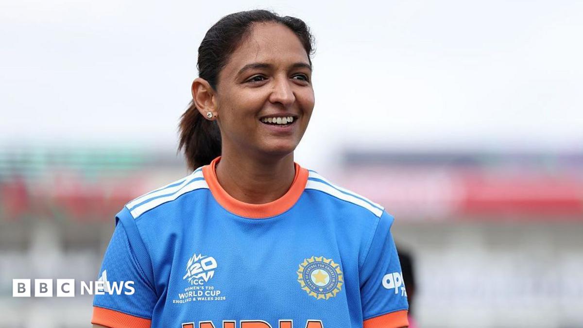 Harmanpreet Kaur of India wearing a blue jersey with orange details reacts at the coin-toss