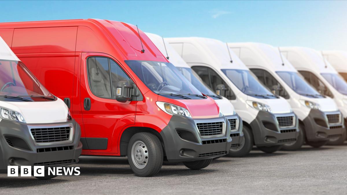 A red van among a line up of white vans