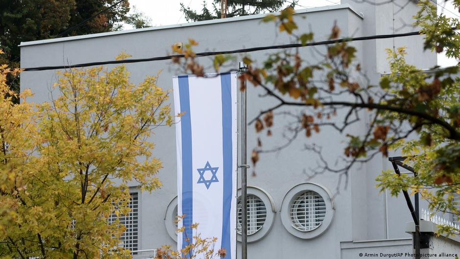 Gray building with Israeli flag hanging before it
