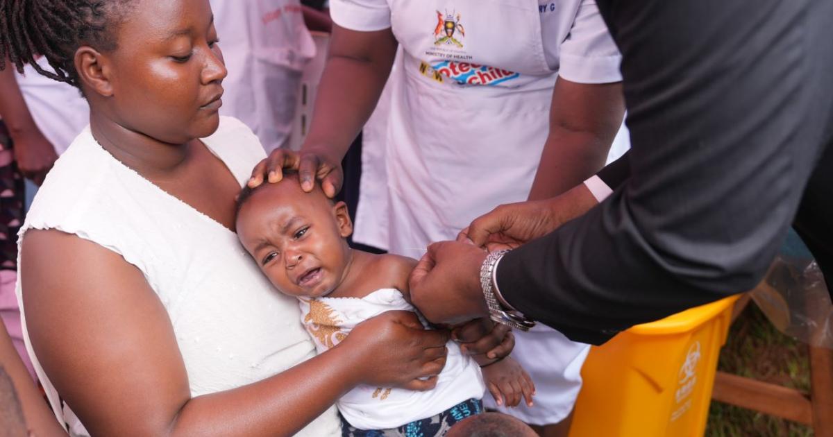 Dr Chris Baryomunsi, Uganda's Minister of Health vaccinating 9 month old Sly at Wakiso