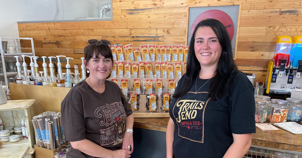 Twila Wedrick and Shianna Smart stand in front of the jerky display set up at The Grainery Bakery in Gull Lake, Sask