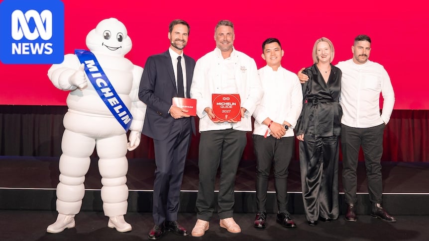 Chefs and staff stand in a row to pose for photos with Michelin tyre mascot