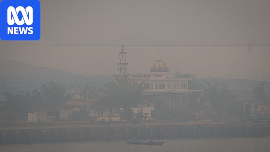 A mosque and a ship floats on the river covered by haze