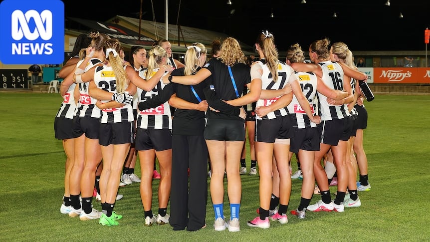 A group of Collingwood AFLW players gather in a circle on the ground after losing a match