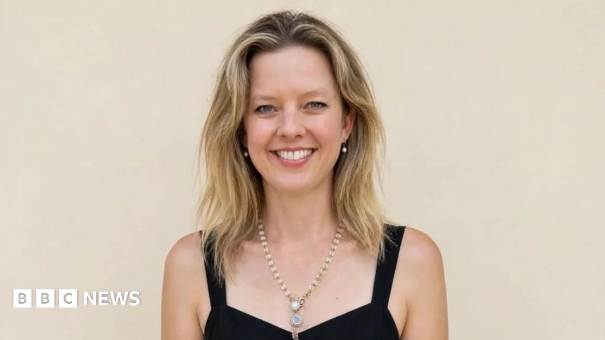 Dr Hannah Terry smiles at the camera. She has blonde hair and is wearing a black dress